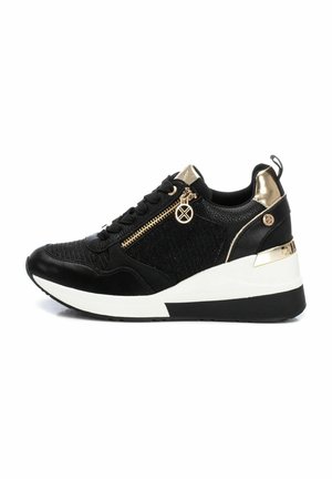 Zapatillas negras con parte superior de tela texturizada, detalles en dorado, un zipper decorativo y una suela cuña blanca. Presenta cordones y un charm con el logo.