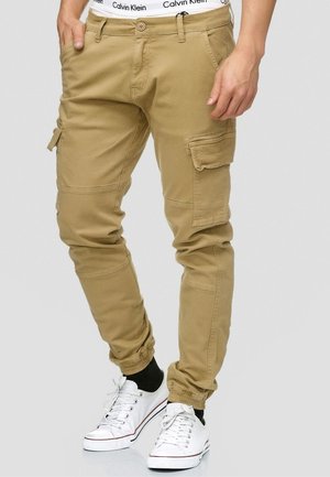 Khaki cargo bukser med tapered fit, der har flere lommer, elastiske manchetter og en Calvin Klein-taljebånd. Fremstillet af en robust bomuldsblanding.