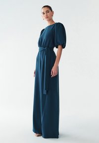 Teal maxi jurk met een ronde halslijn, pofmouwen en een vastgebonden tailleband. Glad materiaal, vloerlengte met een ontspannen silhouet.