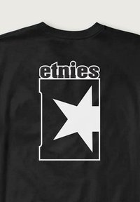 Camiseta de algodón negra con un gran gráfico blanco que presenta la palabra "etnies" y una estrella dentro de un contorno rectangular en la parte posterior.