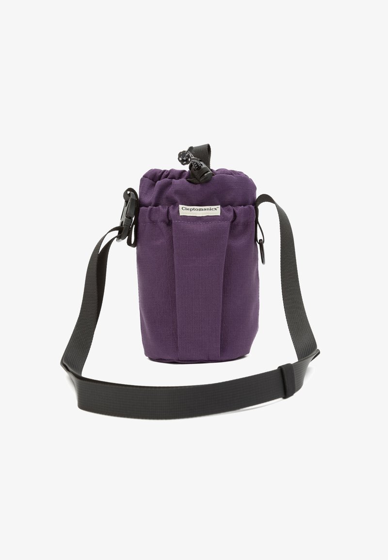 Purple fabric cylindrical bag with drawstring closure, front label "Cleptomanicx," and adjustable black shoulder strap.