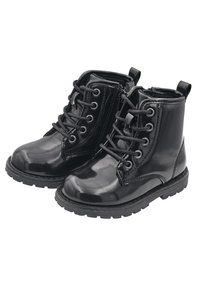 Botas de tobillo de charol negro con cordones, detalle de cremallera, suela de goma y asa de transporte. Presentan punta redonda y ojales de metal.