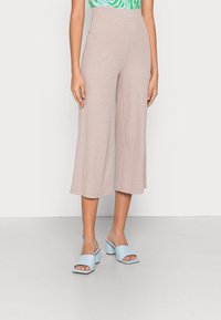 Light beige ribbed wide-leg pants with a high waist, paired with light blue block-heel mules. Smooth texture and simple design details.