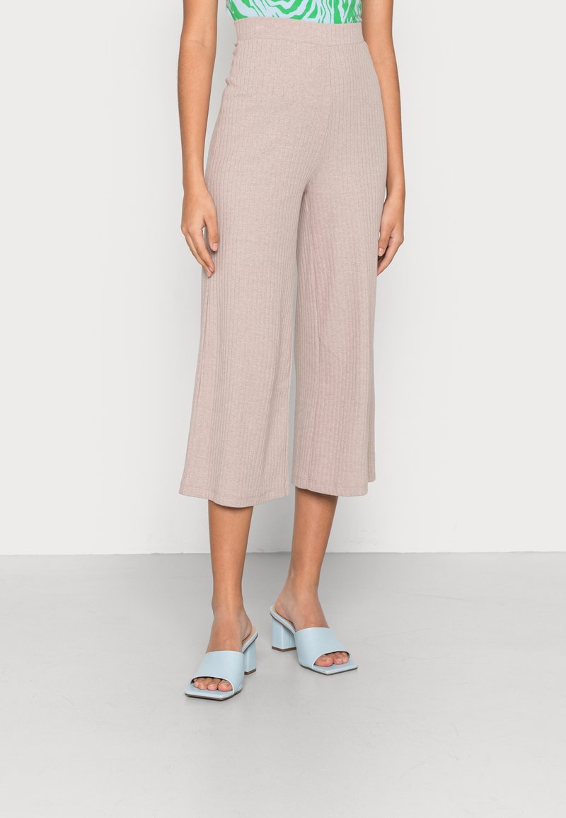 Light beige ribbed wide-leg pants with a high waist, paired with light blue block-heel mules. Smooth texture and simple design details.