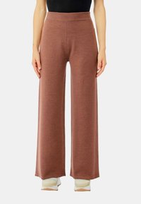 Pantaloni a gamba larga in un morbido tessuto brown testurizzato. Alta vita elastica. Design casual con una vestibilità rilassata. Adatti per l'uso quotidiano.