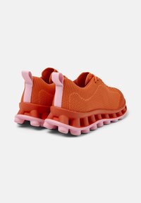 Orange athletic shoes with pink soles and accents, showcasing a breathable knit upper and textured rubber sole, viewed from the back.
