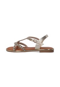 Metallisch goldene Sandalen mit überkreuzten Riemen und Strassakzenten. Flache Sohle mit Schnallenverschluss und braunem Fußbett. Mid-Heel-Design.