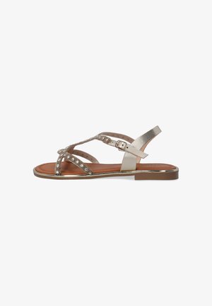 Metallic gold sandals with crisscross straps and rhinestone accents. Flat sole with a buckle closure and brown insole. Mid-heel design.