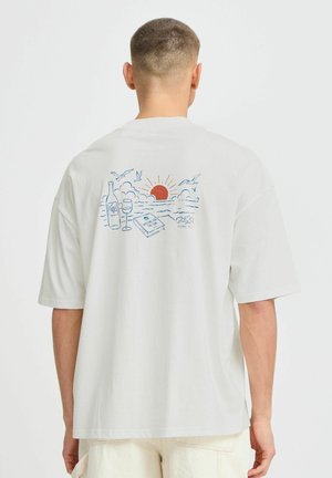 Lysegrå bomulds-t-shirt med korte ærmer, der har et farverigt trykt design af en solnedgang, vinflasker og en bog på ryggen.