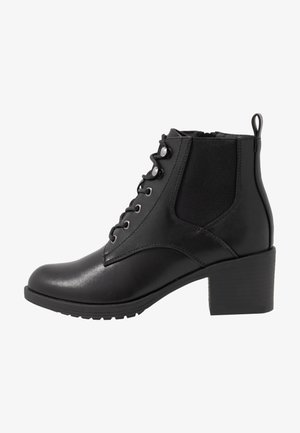 Botas de tornozelo pretas feitas de couro liso, com bico quadrado, fecho de cordão à frente, painéis laterais elásticos e um salto robusto para estabilidade.