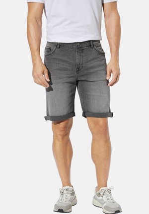 Graue Denim-Shorts mit umgeschlagenen Säumen, Fünf-Taschen-Design und subtilen Verblassungen. Getragen mit einem weißen T-Shirt und grauen Sneakers.