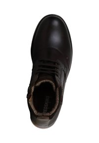 Zapatilla de cuero marrón con puntera redondeada, cordones y forro de textil con patrón. Cuenta con una suela de goma texturizada y un logotipo en la plantilla.