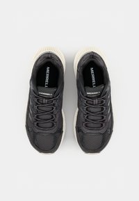 Black mesh athletic shoes with light gray soles, featuring rounded toes, thick laces, and prominent logo detailing on the tongue.
