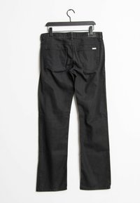 Pantalones vaqueros de mezclilla negra con un diseño de pierna recta. Presentan dos bolsillos traseros y una sutil etiqueta de la marca en la cinturilla. Textura suave, costuras mínimas.
