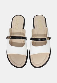 Infradito sintetici bianchi con una fascia in pelle verniciata nera. Presentano una suola liscia con dettagli cuciti e un piccolo accentro di marca.