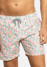 Bañador floral en rosa con flores multicolores y hojas verdes. Cuenta con una cinturilla elástica y un cordón para ajustarlo.