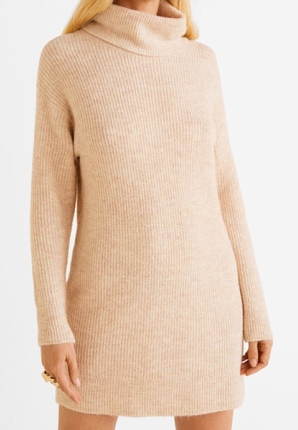 Abito a collo alto a coste in morbido beige, maniche lunghe, vestibilità leggermente oversize, realizzato in tessuto a maglia strutturata, lunghezza fino al ginocchio.
