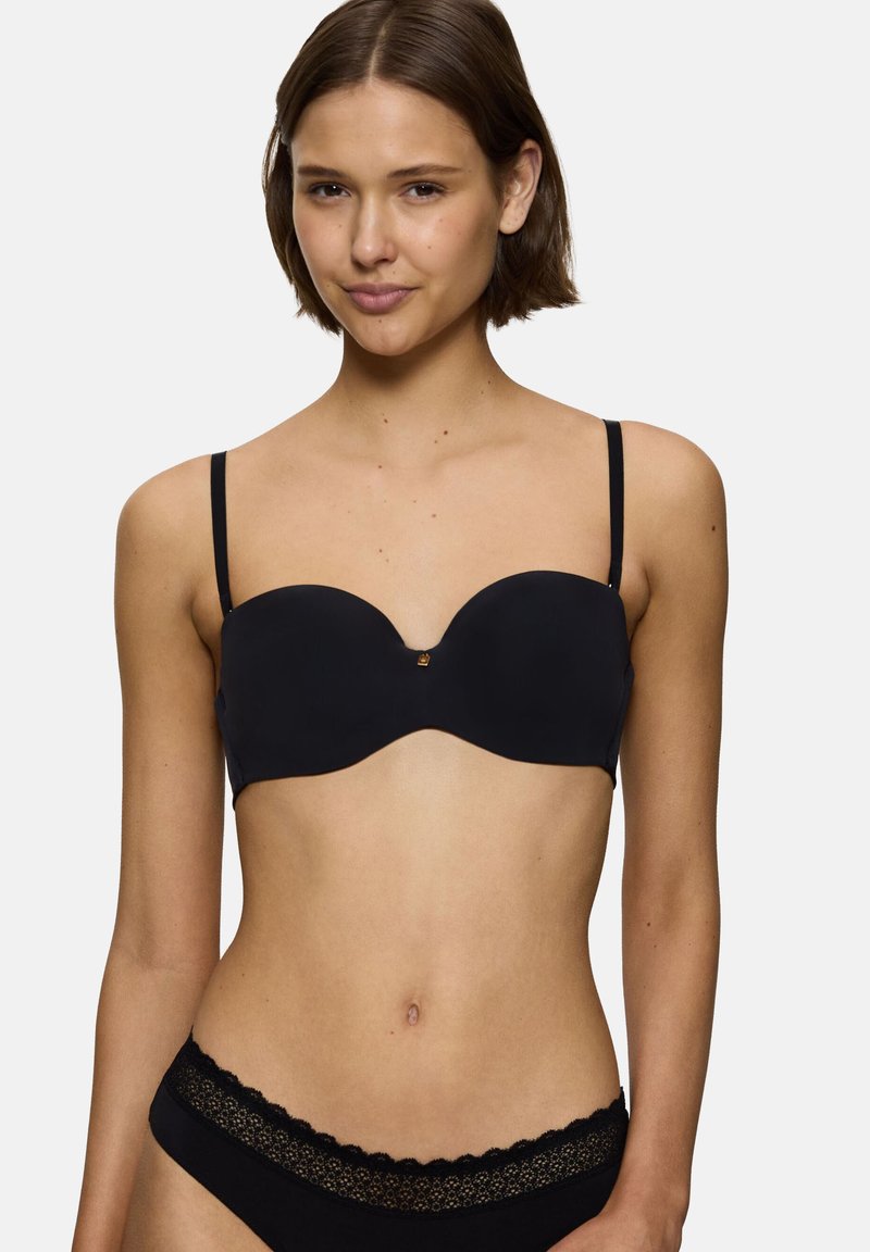 Zwarte gewatteerde beha met verstelbare bandjes, naadloos ontwerp, zacht materiaal en een subtiel gouden accent in het midden.