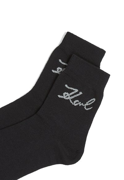Chaussettes noires en coton à hauteur de cheville avec des bords côtelés et un texte brodé argenté ressemblant à "Bonjour" sur le côté. Texture lisse, design léger.
