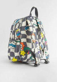 Sac à dos avec un motif à carreaux noir et blanc, présentant des graphismes de dessins animés colorés. Bretelles grises ajustables et une poignée sur le dessus.