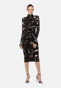 Czarna midi sukienka z długim rękawem i wysokim dekoltem, ozdobiona białym wzorem w plamy, wykonana z elastycznego materiału, podkreślająca dopasowaną sylwetkę.
