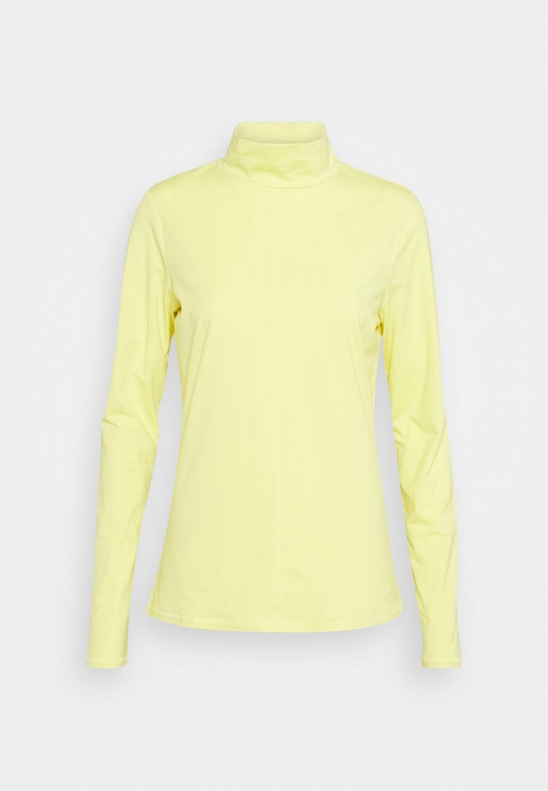 Långärmad polotröja i ljusgul tyg, med en figurnära design, mjuk textur och hög krage. Platta sömmar längs sidorna.