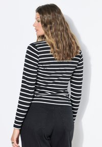 Schwarzes und weißes gestreiftes Langarmshirt mit enganliegendem Design, runder Ausschnitt und glatter Stoffqualität.