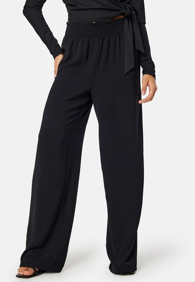 Zwarte wijde broek van zacht materiaal, met een elastische tailleband voor comfort en een relaxte pasvorm, geschikt voor casual kleding.
