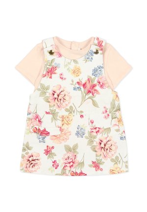 Krótki różowy blady różowy T-shirt w połączeniu z białą sukienką na ramiączkach w kwiaty z różowymi, żółtymi i niebieskimi kwiatami oraz przednimi kieszeniami.