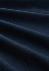 Tessuto blu navy con una trama liscia, caratterizzato da pieghe sottili e un colore uniforme. Nessun motivo o hardware notevole visibile.