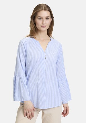 Blouse rayée bleu clair et blanche avec un col en V, trois boutons décoratifs et des manches longues évasées, fabriquée en tissu de coton doux.