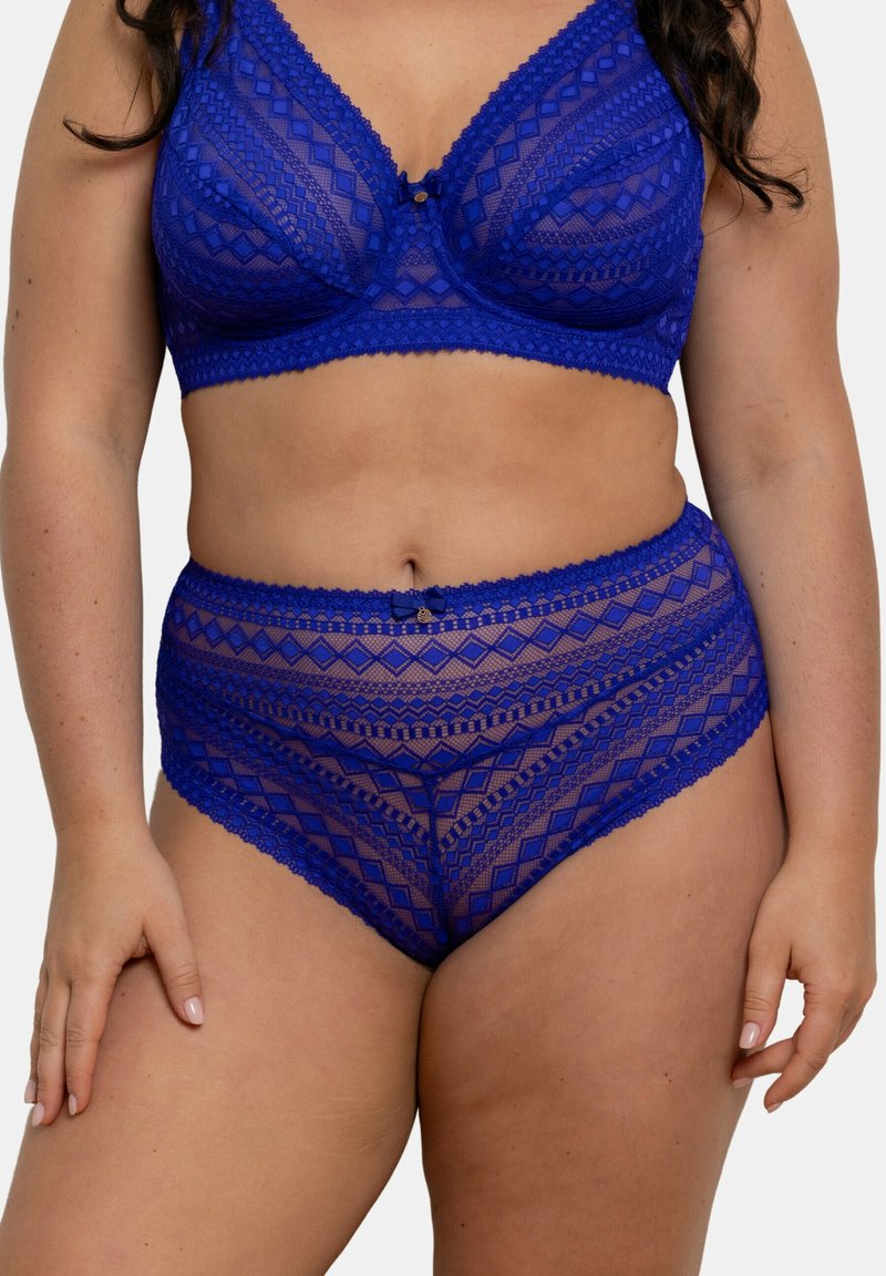 Ensemble de bralette en dentelle et de sous-vêtements taille haute en bleu vif, présentant des motifs géométriques et des bords festonnés avec un détail de nœud décoratif.