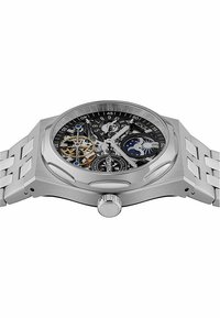 Montre en acier inoxydable argenté avec un cadran squeletté, un fond noir, un mécanisme d'engrenages complexe, un affichage de phase de lune et un bracelet texturé.