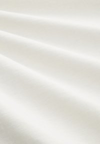 Tissu blanc avec une texture lisse et un léger éclat, affichant de douces plis et rides, suggérant un matériau léger.