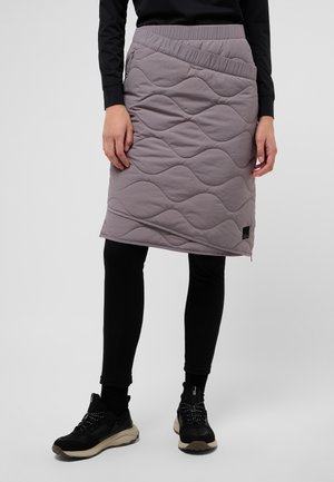 Gequiltede grijze rok met een gestructureerd golfpatroon, voorzien van een elastische tailleband en een zijrits, gedragen over zwarte leggings en sneakers.