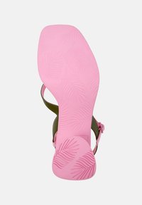 Green sandal with a pink rubber sole, featuring a leaf pattern and a strap design. The sole is textured for grip and stability.