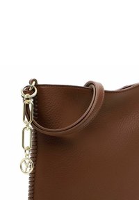 Brown leather handbag with a textured surface, top handle, gold-tone hardware, and a chain accent along the side.