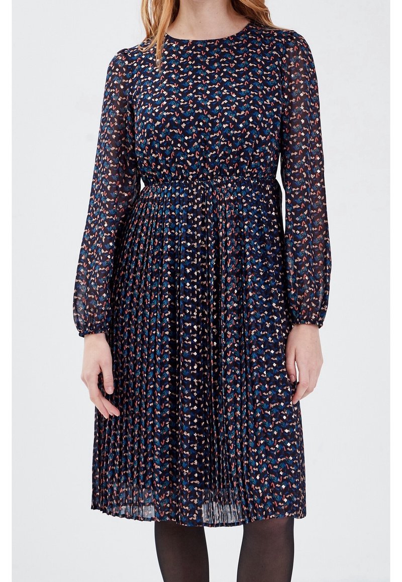 Robe plissée bleu marine avec de longues manches transparentes, présentant un motif abstrait multicolore et une taille cintrée.