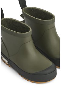 Bottines en caoutchouc vert avec des semelles en caoutchouc noir texturé, doublure en laine isolante et une languette pour un enfilage facile, présentant une finition lisse.