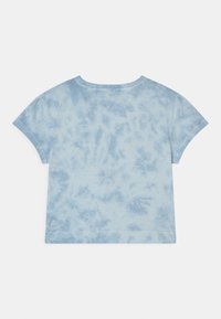 Jasnoniebieska koszulka z efektem tie-dye o luźnym kroju, krótki rękaw i miękka faktura. Okrągły dekolt i dół z casualowym designem.