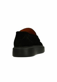 Zwarte leren schoenen van suede met een ronde neus, een lage profiel en dikke rubberen zool. Gedetailleerde stiksels langs de naad zorgen voor textuur. Aan de binnenkant is er een bruine voering.