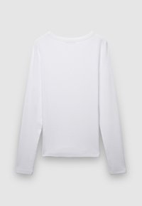 Camicia bianca a maniche lunghe in tessuto di cotone morbido, con scollo rotondo e orlo dritto, texture liscia con dettagli minimi.