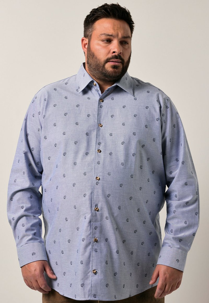 Camisa abotonada azul claro con un pequeño estampado floral, mangas largas y una tela texturizada, con puños redondeados y botones marrones.