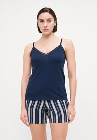 Mörkblå ärmlös tanktop med spetsdetaljer, parat med randiga shorts i mörkblått och krämfärgat, med avspänd passform och mjukt tyg.