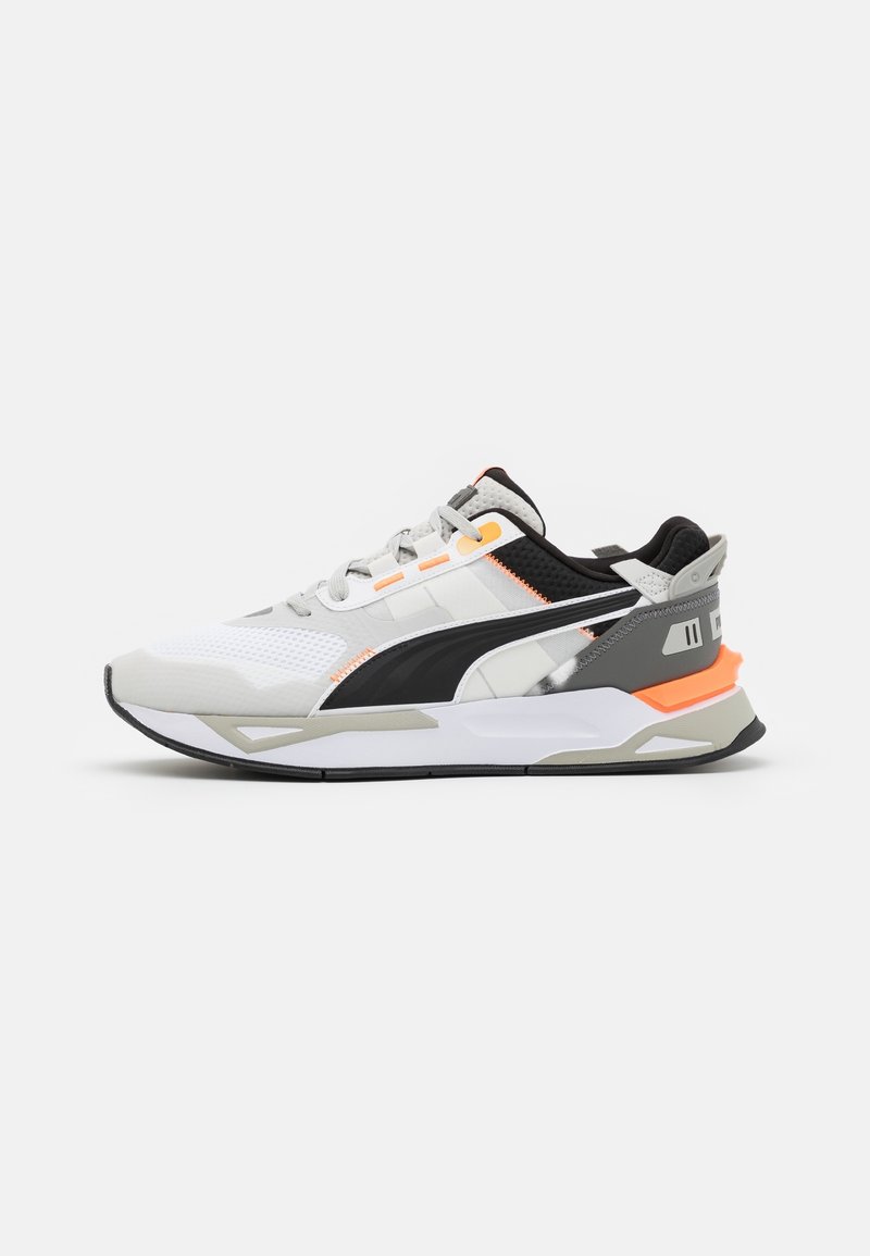 Baskets de sport blanches, grises et noires avec des accents orange, bout en mesh, semelle épaisse et logo Puma noir sur le côté, vues de profil.