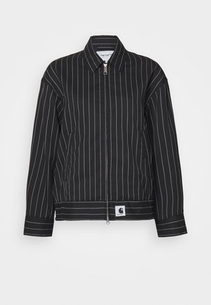 Black jacket with white vertical stripes, zippered front, pointed collar, and a logo patch at the hem. Made from a smooth fabric.