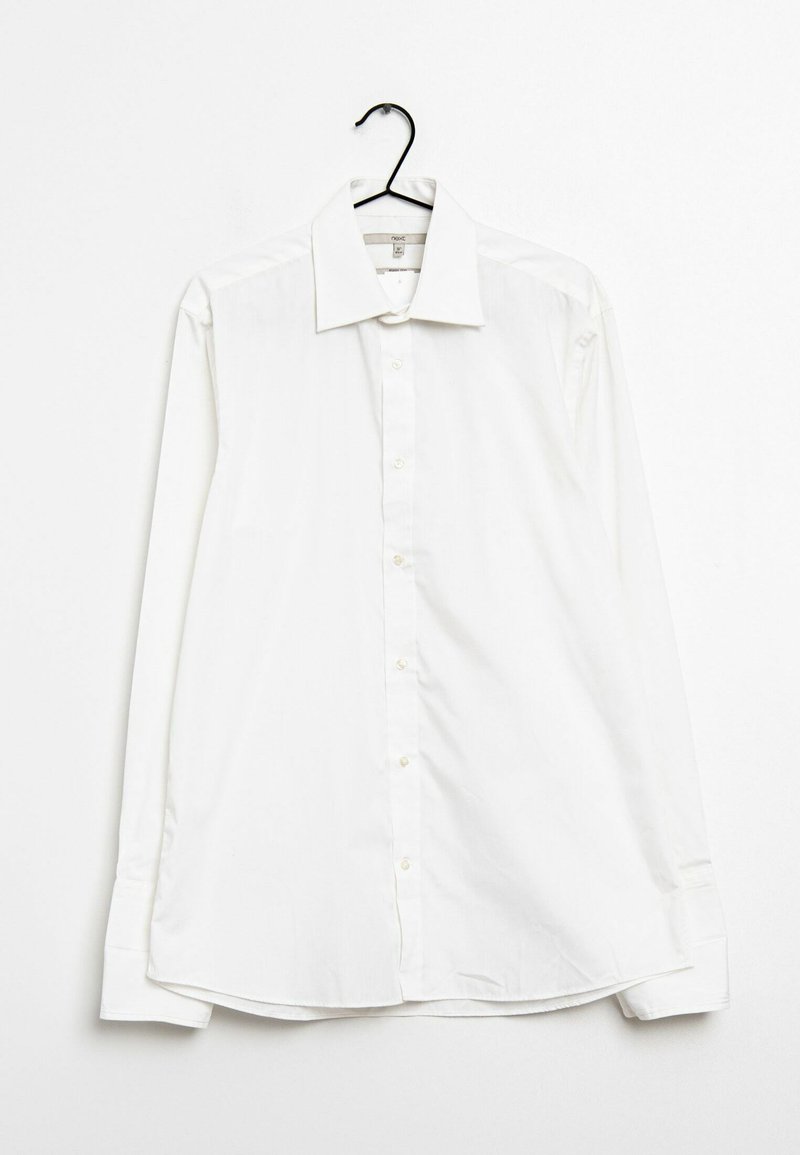 Camisa blanca de manga larga y botones colgada en una percha. Presenta un cuello clásico, botones en la parte delantera y un dobladillo ligeramente redondeado. Textura lisa y sencilla.