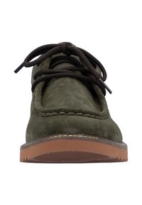 Zapato de gamuza verde con cordones marrones y detalles cosidos, que presenta una puntera redonda y una suela de goma con un fondo texturizado para mayor agarre.