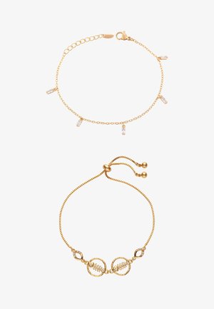 Dwie złote bransoletki łańcuchowe, jedna z pięcioma małymi prostokątnymi przezroczystymi zawieszkami, druga z regulowanym zapięciem i dwoma okrągłymi zawieszkami w kształcie liści.