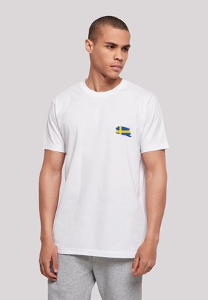 Weißes Baumwoll-T-Shirt mit einem blauen und gelben Pinselstrichdesign, das der schwedischen Flagge auf der linken Brust ähnelt. Kurze Ärmel.